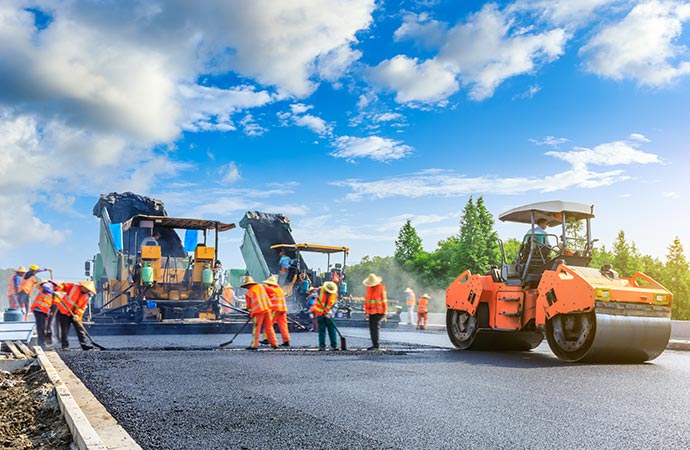 Workers are repairing asphalt paving and concrete for enhanced durability.
