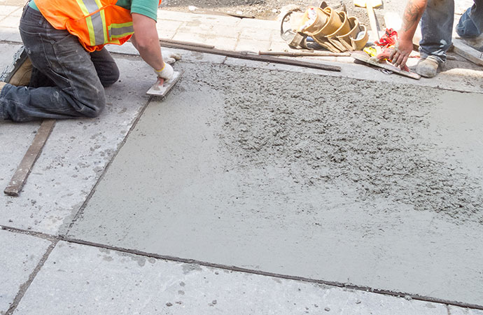 Professional worker repairing sidewalk concrete